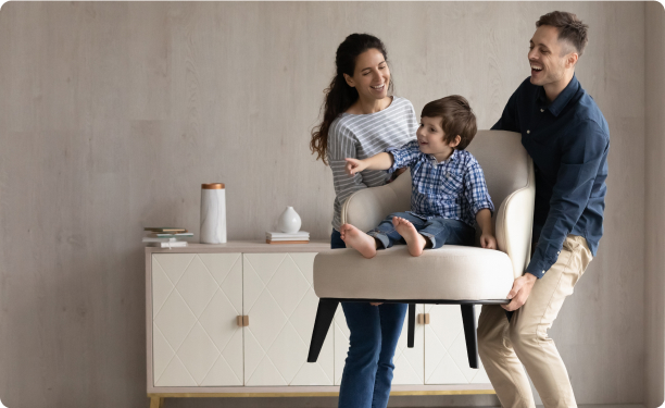 Couple lifting a chair with their son on it
