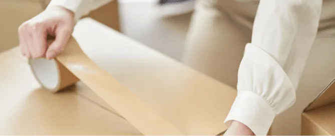 Woman closing boxes with tape